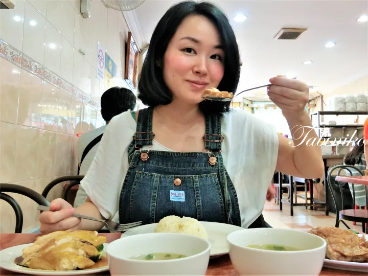 マレーシアの飲食店で海南鶏飯を食べている女性