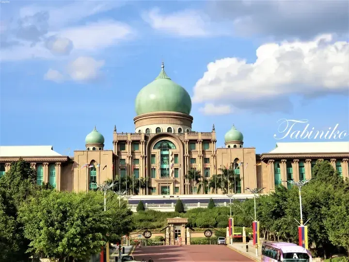 The grand Putra Mosque with its iconic green dome and Islamic architecture in Putrajaya, Malaysia.