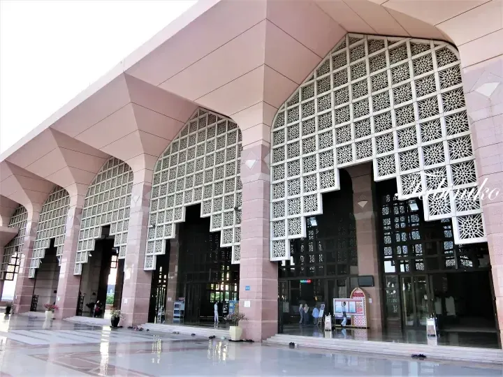 Pink granite facade with geometric lattice windows at Putra Mosque in Putrajaya, Malaysia.