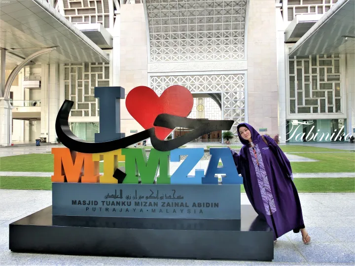 プトラジャヤのMasjid Tuanku Mizan Zainal Abidinで、カラフルなI Love MITZAの看板の前でポーズをとる女性