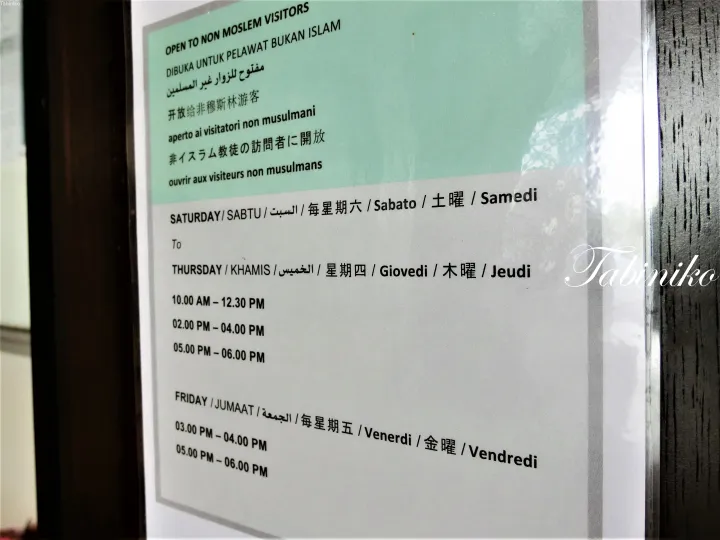マレーシアのモスクで非ムスリム訪問者のための開館時間を示す看板。木曜日、金曜日、土曜日の時間帯を記載。