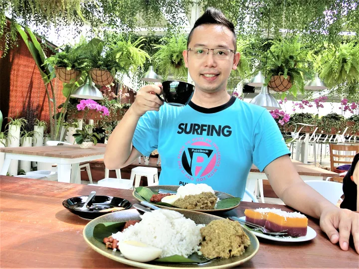 ナシレマックとクイ・ラピスを前にコーヒーを飲む男性。