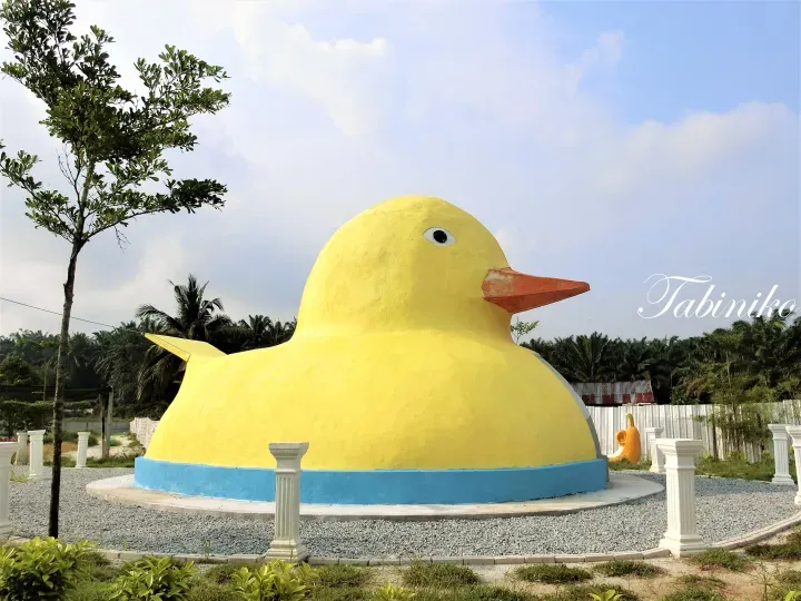 Giant yellow rubber duck sculpture at Taman Kuching, a popular photo spot in Sarawak, Malaysia.