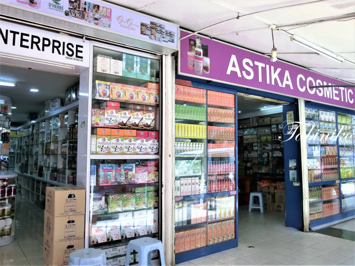 化粧品や健康食品を陳列する「Astika Cosmetic」と「ENTERPRISE」の店舗外観。