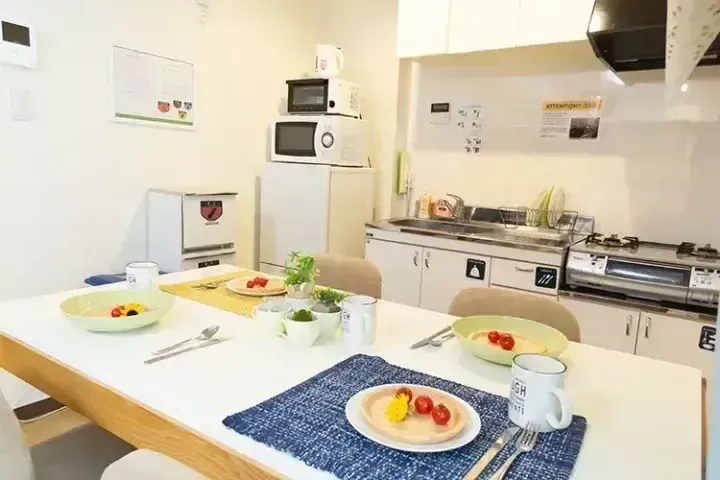 明亮的現代廚房配有擺好早餐的餐桌，採用白色家電和極簡設計。