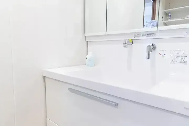 配有水槽、水龍頭和藥櫃的現代白色浴室洗手台。