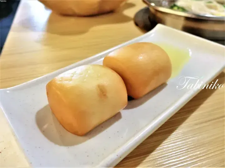 レストランの白い長皿に盛られた、ふっくらとした蒸しパン2個。