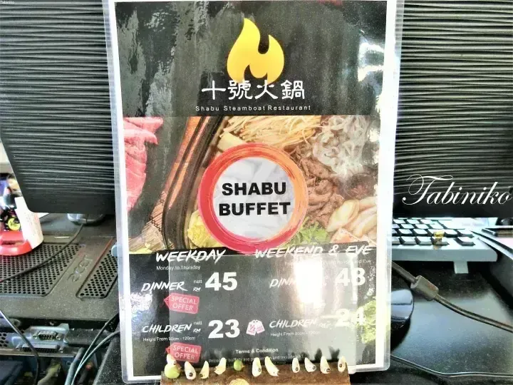 Menu stand for Shabu Steamboat Restaurant displaying Shabu Buffet prices for weekdays and weekends.