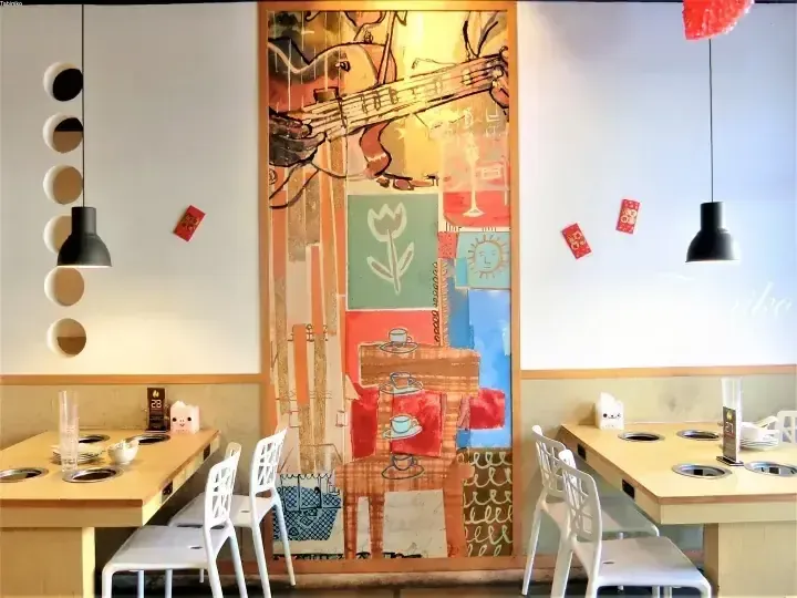 Modern dining area with wooden tables, white chairs, and a colorful abstract mural featuring a guitar.
