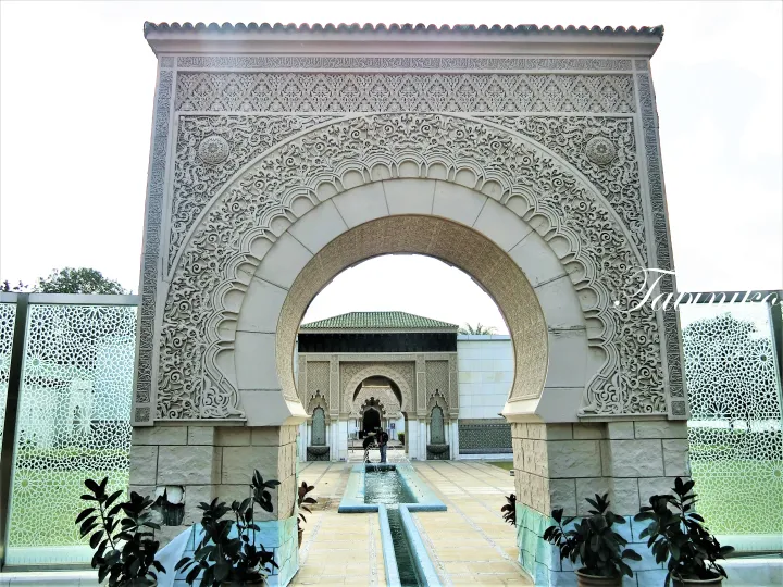Ornate Moorish archway at Istana Budaya in Kuala Lumpur, featuring intricate stonework and a central water fountain.