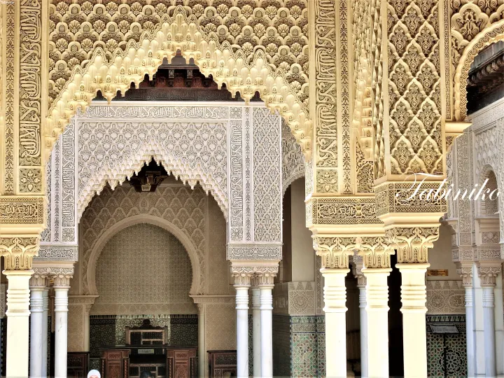 Intricate Islamic architectural details featuring ornate arches, columns, and Arabic calligraphy at a Malaysian heritage building.