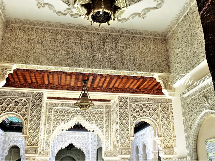 Intricate Islamic geometric plasterwork and carved wooden ceiling in a traditional Malay house at the Islamic Arts Museum Malaysia.