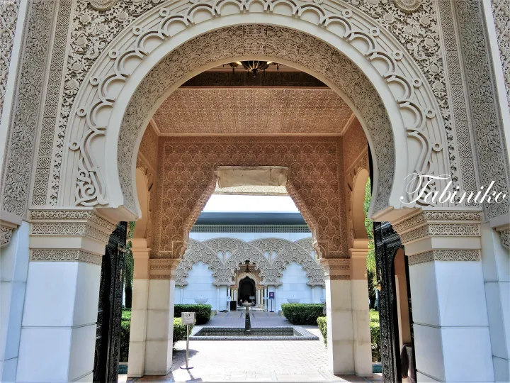 Ornate Moorish archway entrance at The Suria KLCC hotel lobby featuring intricate stucco carvings and a view of the courtyard fountain.