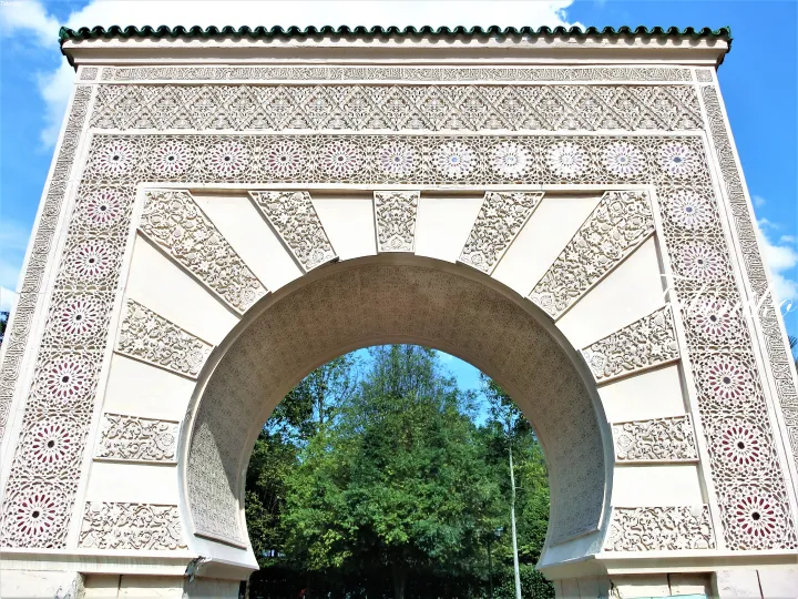 Ornate Moroccan-style archway with intricate tilework and calligraphy at the entrance of a park in Malaysia