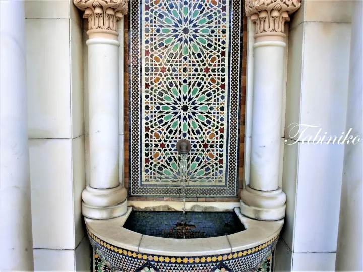 Ornate fountain with intricate geometric tiles and marble columns, typical of Islamic architecture in Malaysia.