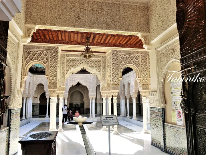 Ornate interior courtyard of Istana Jahar with intricate stucco arches, marble columns, and a central fountain.