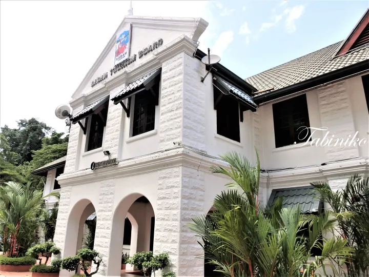 Sabah Tourism Board building exterior with white facade, arched entrance, and tropical plants.