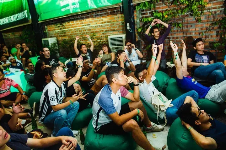 Fans watching a match on bean bags at an outdoor Heineken event in Malaysia.