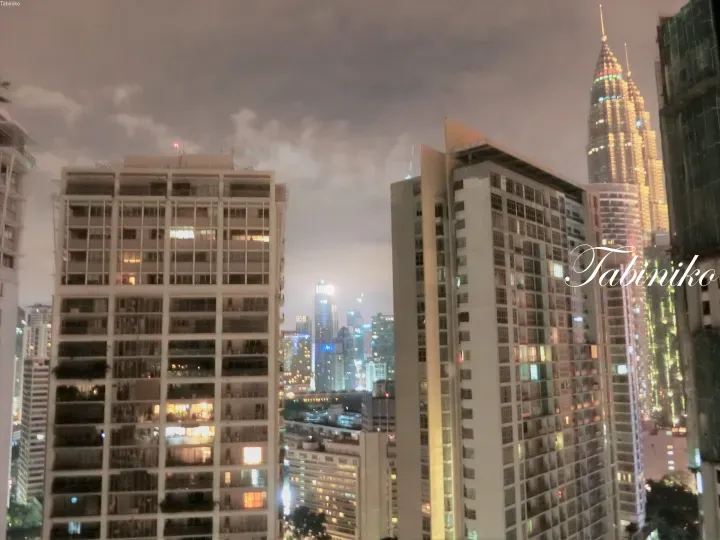 展示双子塔和周围高层住宅的吉隆坡夜景。