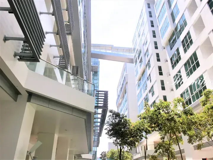 Modern white high-rise buildings connected by skybridges in a landscaped courtyard