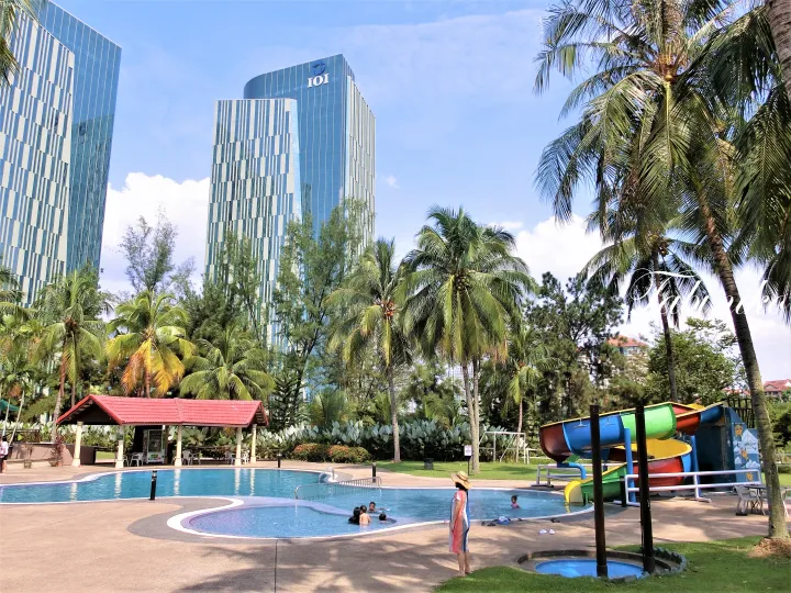 背景にIOI Resort Cityのタワーが見える、ウォーターパーク付きのプールとヤシの木
