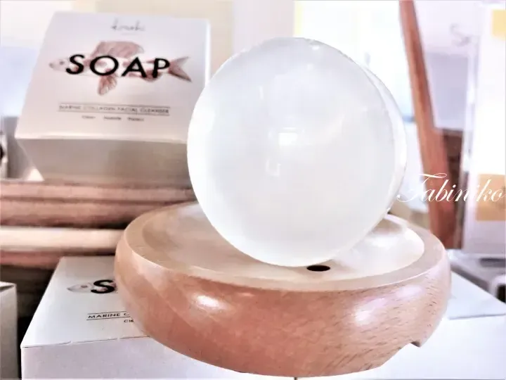 White spherical soap on a wooden dish beside a box labeled Marine Collagen Facial Cleanser