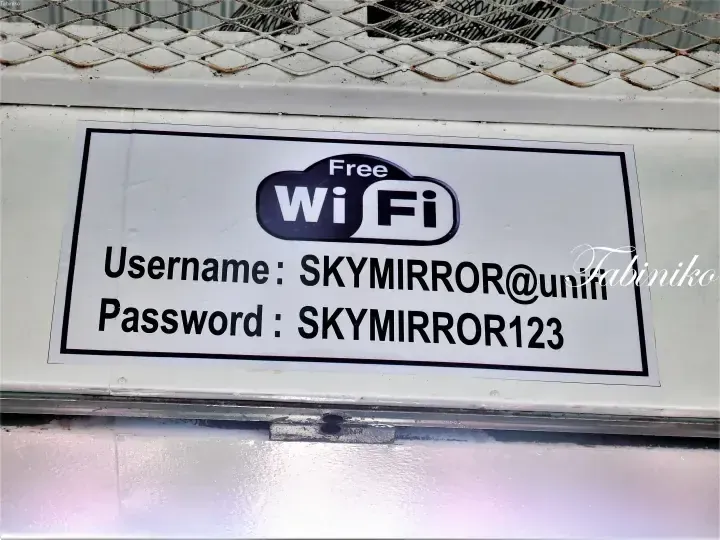 Free WiFi sign at SKYMIRROR with username SKYMIRROR@unifi and password SKYMIRROR123 displayed on a white background.