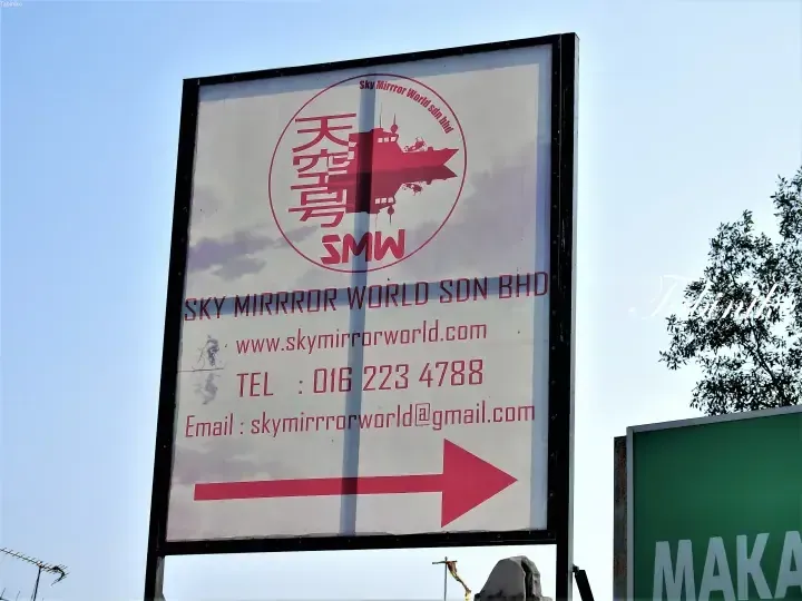 Signboard for Sky Mirrror World Sdn Bhd with contact details and a directional arrow pointing right.