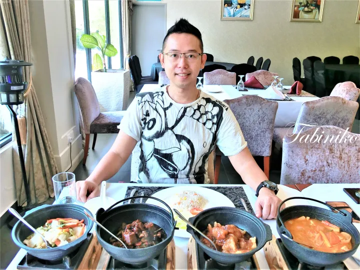 テーブルに並んだ4つの土鍋料理とチャーハンを楽しむ男性の写真。