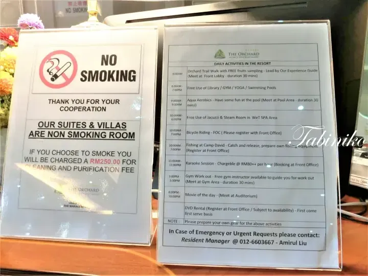 The Orchard resort signage displaying a no smoking policy and daily activity schedule.