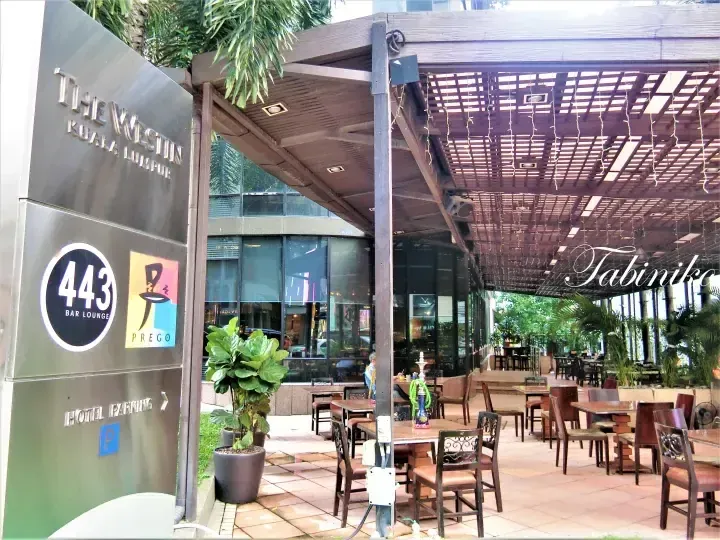 The Westin Kuala Lumpur entrance sign showing 443 Bar Lounge and Prego logos near the outdoor patio seating area.