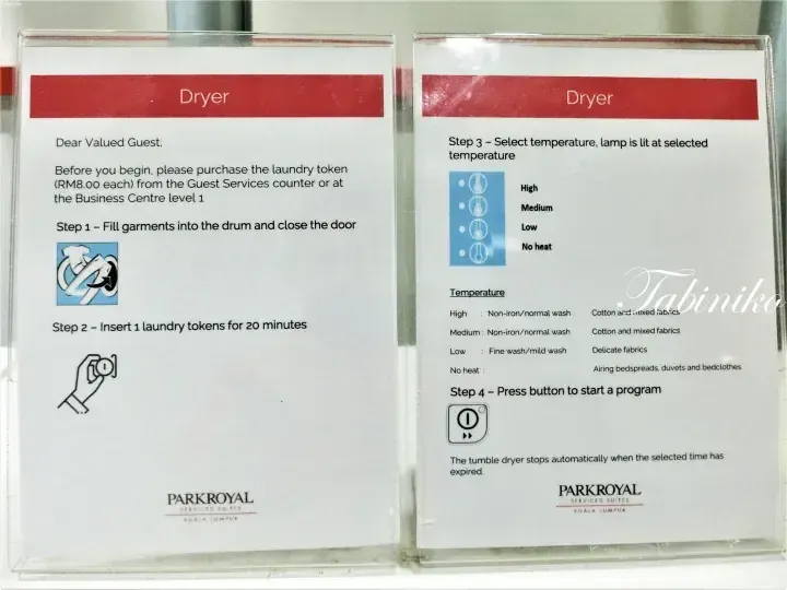 Dryer instruction signs at PARKROYAL Serviced Suites Kuala Lumpur showing laundry token purchase and usage steps.