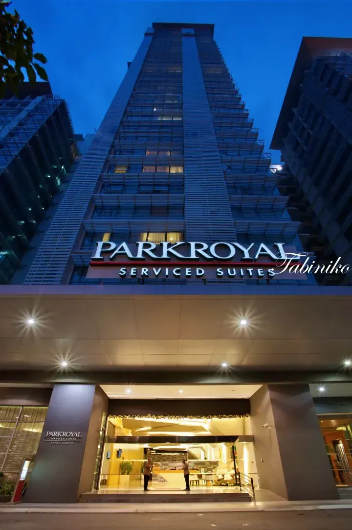 Parkroyal Serviced Suites Kuala Lumpur exterior at dusk, showing the tall modern building facade and illuminated entrance.