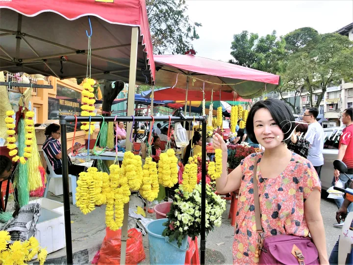 クアラルンプールのWat Buddha Jayanti近くの屋台で、マリーゴールドの花輪を持つ女性。