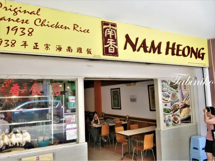 Nam Heong restaurant storefront with yellow signage advertising Original Chinese Chicken Rice since 1938, displaying roasted chickens in the window.