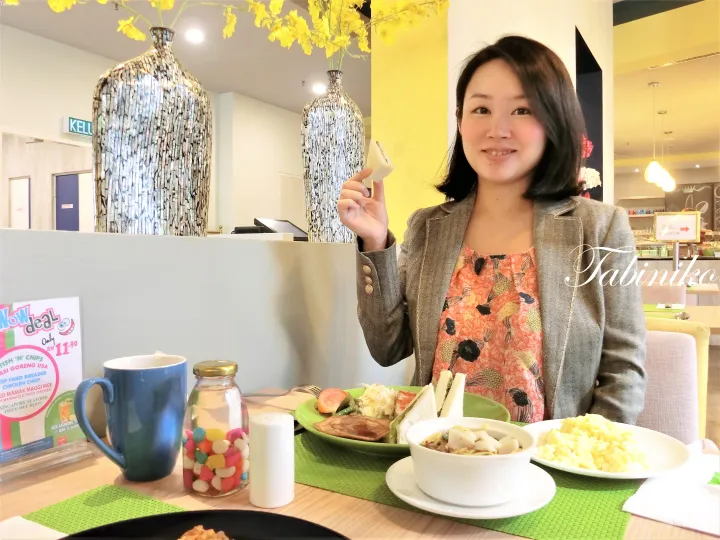 背景に装飾的な花瓶があるカフェで、スクランブルエッグやトースト、青いマグカップを前に食事をする女性。