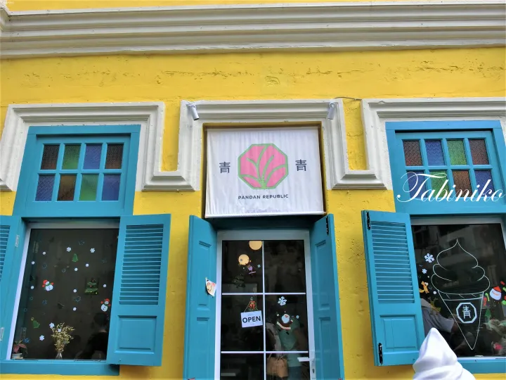 Yellow shophouse facade with blue shutters and a sign for Pandan Republic, a local eatery in Malaysia.