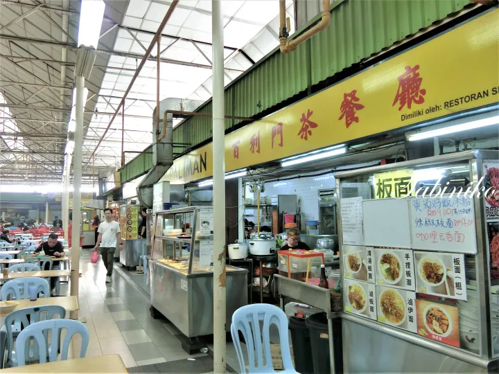 黄色い看板に百利門茶餐庁と書かれたマレーシアのフードコート。板面などのメニューが掲示された店内。