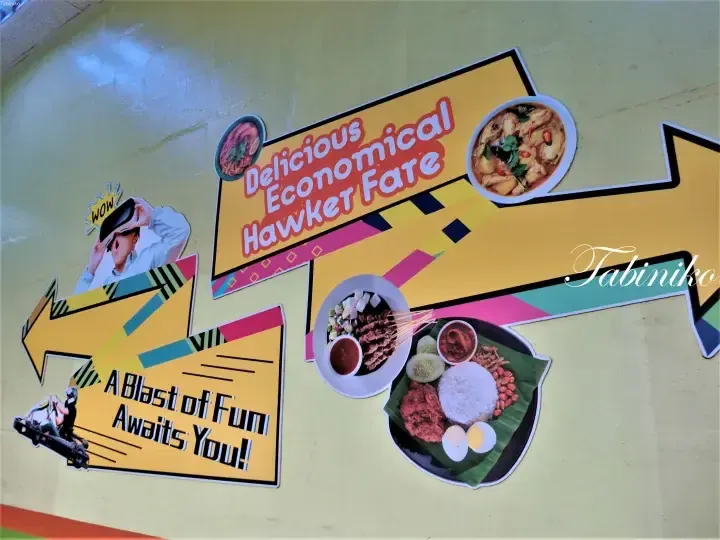 Colorful wall mural advertising Delicious Economical Hawker Fate with images of nasi lemak, satay, and VR go-karting.