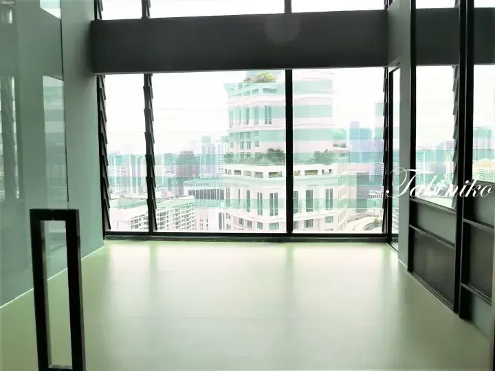 Modern office interior with large windows overlooking the city skyline and Grand Millennium building.