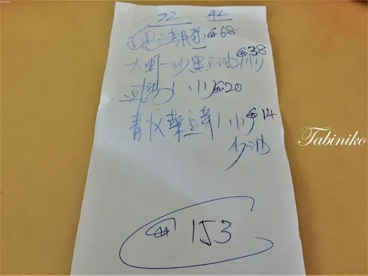 Handwritten Chinese menu listing dishes like stir-fried shrimp and bean sprouts with prices totaling 153.