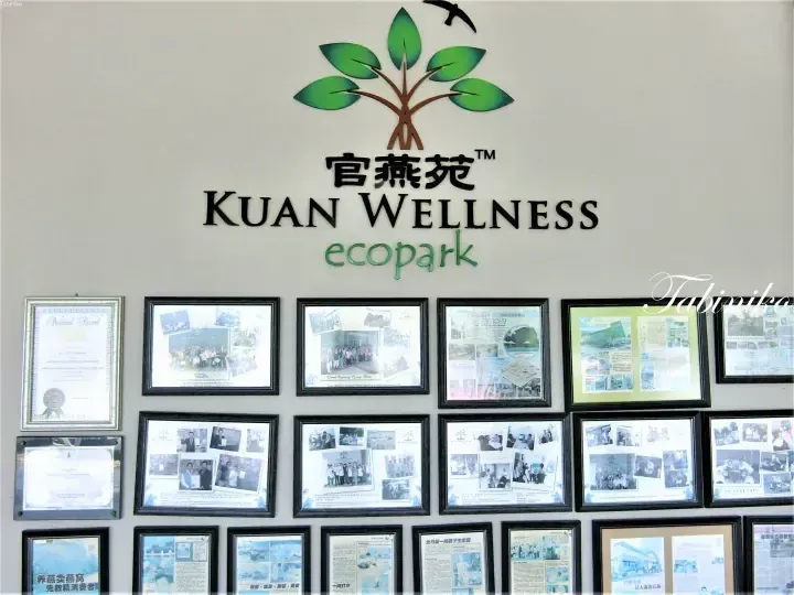 Kuan Wellness Ecopark sign with logo and framed certificates on the wall.