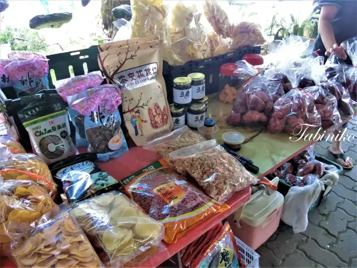 A roadside stall displays various packaged snacks including Chia seeds, Jujube Clamp Walnut, and dried fruits.