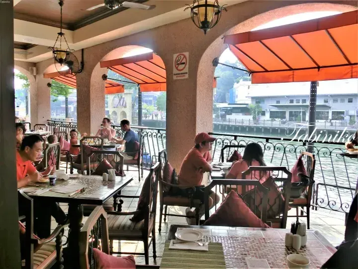 Diners enjoy a riverside meal at the outdoor terrace of The Majestic Hotel Malacca, overlooking the Malacca River.