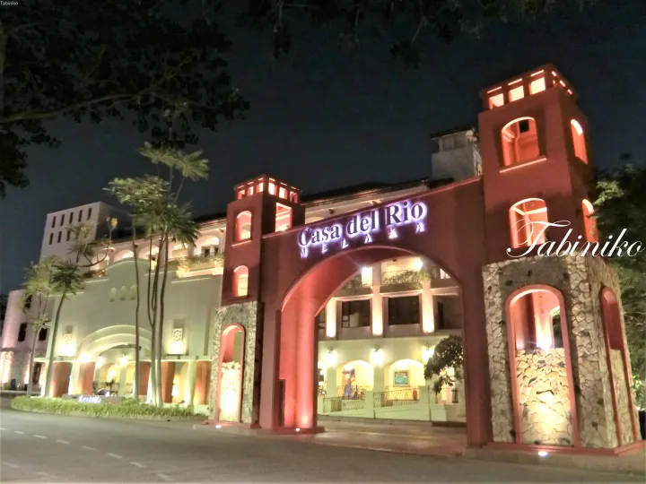 夜間にライトアップされたマラッカの「Casa del Rio」の入り口アーチ。赤と石の建築が特徴的なホテルの外観。