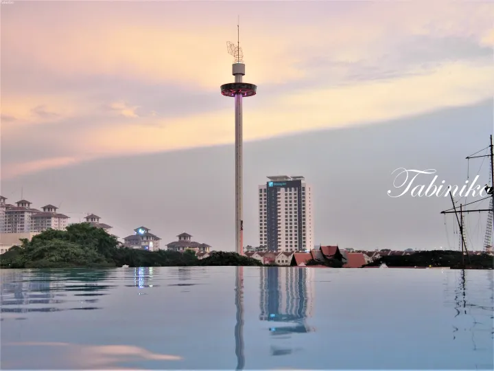 マレーシアのメラン川沿いにあるインフィニティプールからマラッカタワーとホリデイインを望む夕景。
