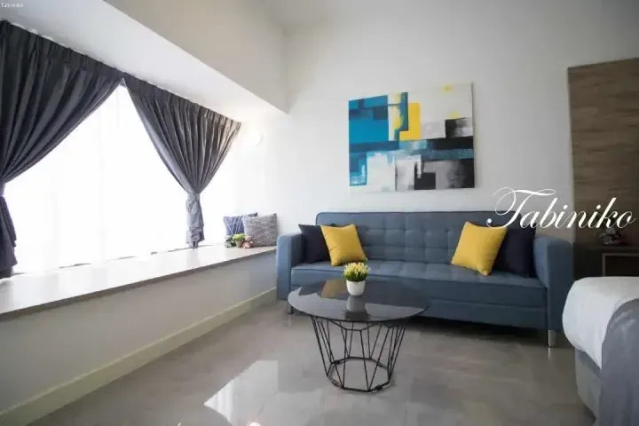 Modern living room with blue sofa, yellow cushions, abstract art, and large window at Tabiniko accommodation