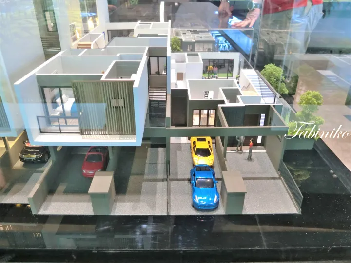 ミニカーや室内のディテールを備えた、現代的な二階建てテラスハウスの建築模型。