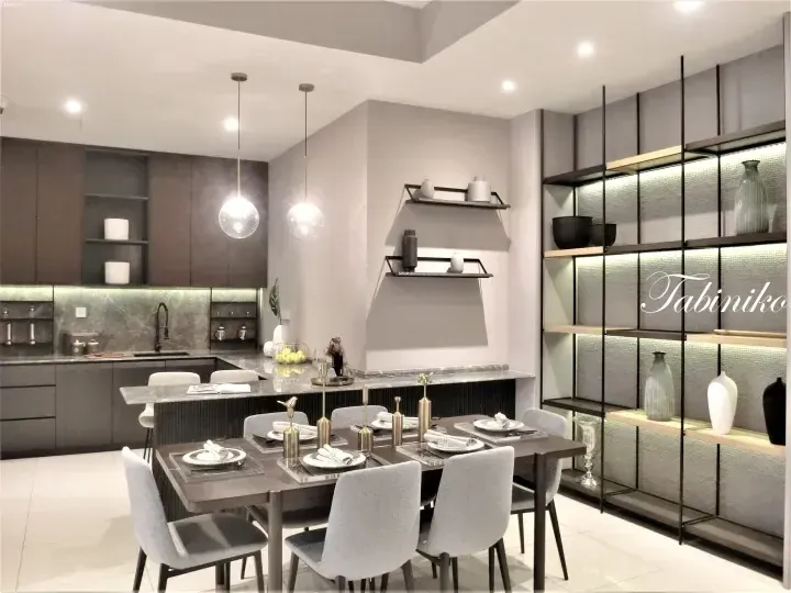 Modern kitchen and dining area with marble countertops, grey cabinetry, and a black metal shelving unit.