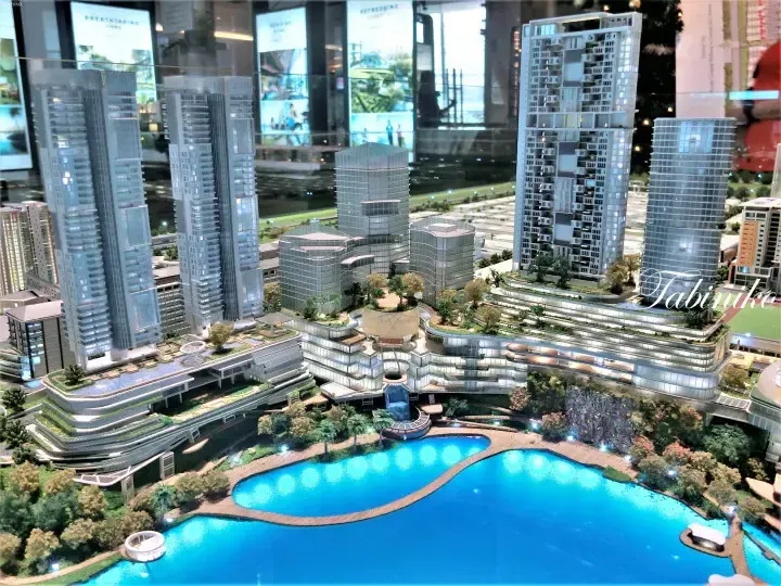 Architectural model of Sunway City showcasing high-rise towers, a large resort-style swimming pool, and lush greenery.